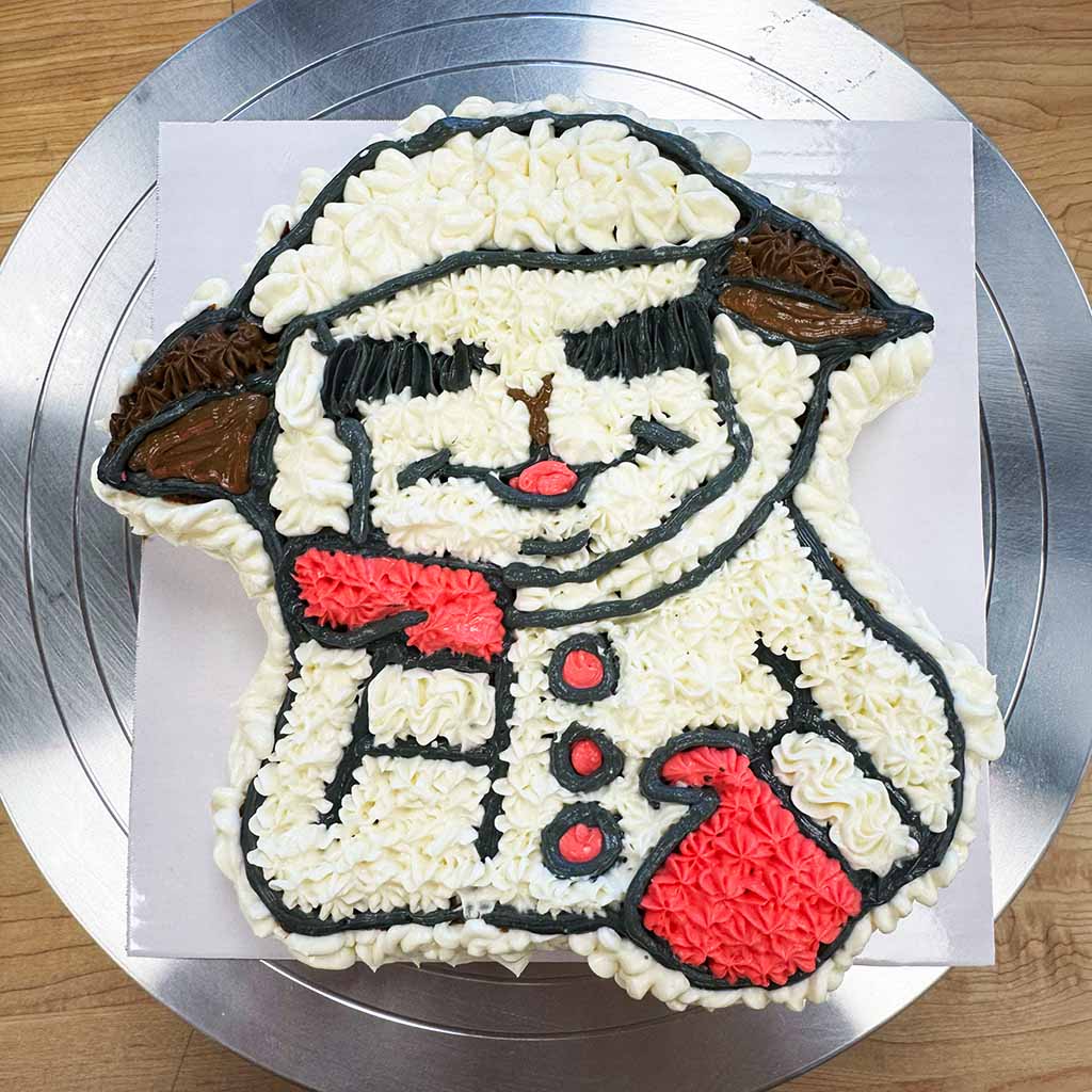 Lamb Chop themed custom dog cake featuring a personalized character design in white, black and red